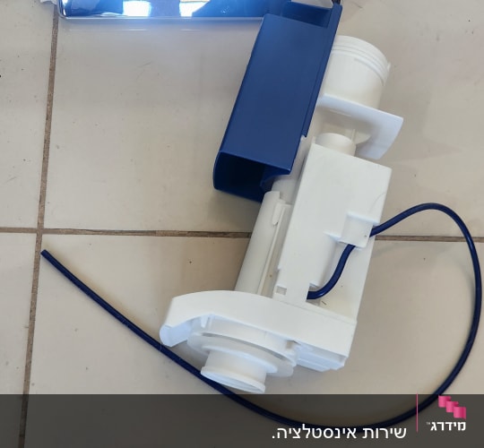 חלקי אינסטלציה על רצפה, כולל צינור וכיסוי מתכת מבריק